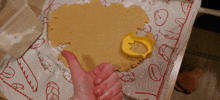 a person giving a thumbs up with a cookie cutter