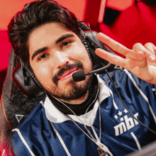 a man with a beard wearing headphones and a shirt that says mbx