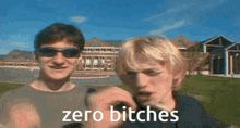 two men wearing sunglasses are standing next to each other and one of them is saying zero bitches .