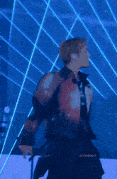 a man is dancing in front of a blue background with the words on leeeun below him