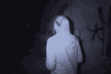 a woman in a white hoodie is standing in the dark