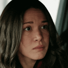 a close up of a woman 's face with a sad expression