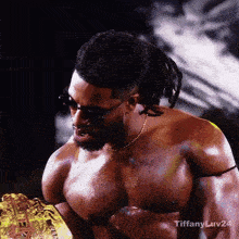 a man without a shirt is wearing sunglasses and a gold chain around his neck ..