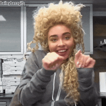 a woman wearing a wig is smiling in front of a chicken box