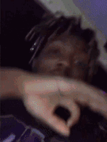 a blurry picture of a person making a peace sign with their hands