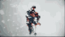 a blurry picture of a person standing in the snow with a silhouette of a person in the background .