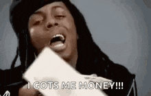 a man with dreadlocks is holding a piece of paper with his mouth open and saying `` i gots me money ! ''