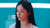 a close up of a woman with long black hair wearing a white shirt .