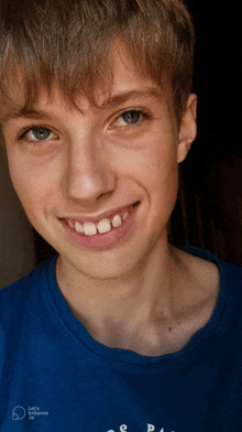 a young boy wearing a blue shirt that says let 's romance on it