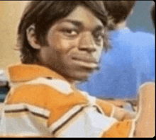 a man in a striped shirt is making a funny face in a classroom .