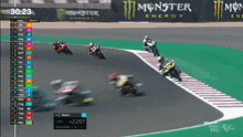 a monster energy sign is behind a group of motorcycles on a race track
