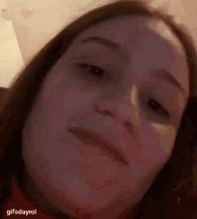 a close up of a woman 's face with a slight smile on her face .