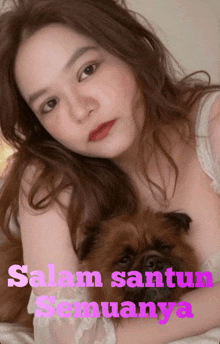 a woman laying on a bed holding a small brown dog with the words salam santun semuanya on the bottom