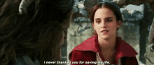 a woman in a red coat is talking to another woman in a snowy forest .