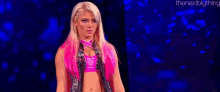 a woman with pink hair is standing on a stage .