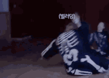 a man in a skeleton costume is laying on the floor in a dark room .