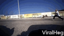 a skateboarder is doing a trick in front of a fence that says ' dallas '