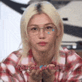 a young man wearing glasses and a plaid shirt is blowing a kiss and says felix solo de budin .