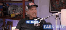 a man in a hat is sitting in front of a microphone with the words dark web on the bottom
