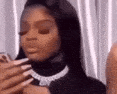 a woman with long nails is taking a picture of herself with her phone .