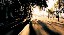 a car is driving down a street with trees on both sides of it