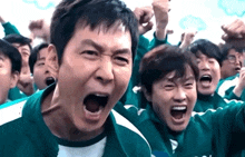 a group of people are screaming with their hands in the air