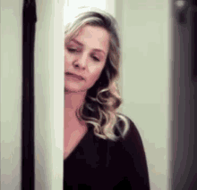 a woman is standing in a doorway looking out .