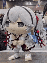 a stuffed doll is standing in front of a sign that says " meet ryan square "