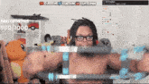 a man without a shirt is lifting a barbell in front of a screen that says bau demons