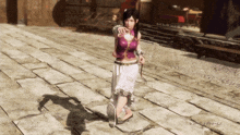 a woman in a purple top and white skirt is walking down a brick sidewalk