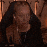 a woman wearing glasses and ear buds is smiling