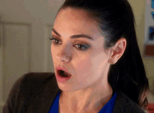 a close up of a woman 's face with her mouth wide open