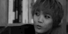 a black and white photo of a young man with short hair .