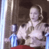 a woman is singing into a microphone while holding a doll .