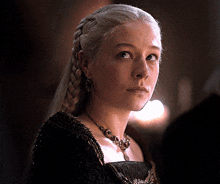 a woman wearing a braided hairstyle and a necklace