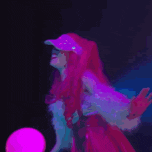 a woman with red hair and a pink hat is holding a pink ball in a dark room .