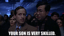 a man in a suit and tie is talking to another man in a crowd with the words " your son is very skilled " .