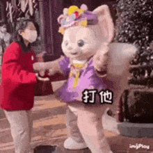 a woman in a red jacket is standing next to a stuffed animal .