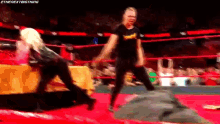 two women are wrestling in a wrestling ring and one of them is wearing a banana shirt .