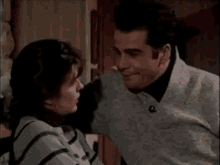 a man and a woman are kissing in a room . the woman is touching the man 's face .