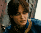 a close up of a woman wearing a blue leather jacket