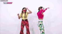 two women are dancing in front of a sign that says ' the show '
