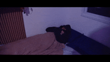 a person in a black hooded jacket is laying in bed