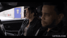 a man sitting in a car with a gifrun.com watermark