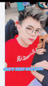a man wearing glasses and a red shirt that says captain gaming on it