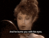 a woman is looking at herself in a mirror with the words " and he burns you with his eyes " below her