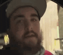 a man with a beard is wearing a hat and a scarf around his neck .