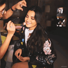 a woman wearing a jacket with the word never on the sleeve is smiling