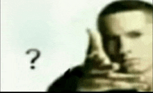 a man talking on a cell phone with a question mark behind him .