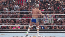a man in a wrestling ring holds a sign that says " justice stop spew in my $ 3 "